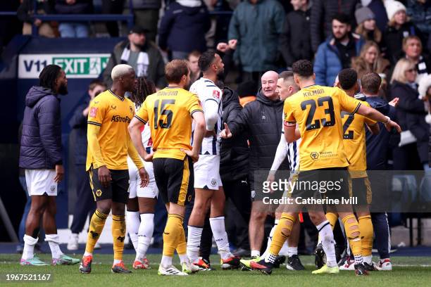 Players of West Bromwich Albion and Wolverhampton Wanderers watch on as stewards and local police officers attempt to stop a pitch invasion during...