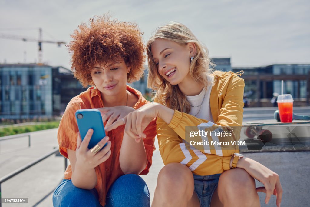 Skater women friends, phone and park with reading, point and meme with discussion for online gossip. Girl, gen z people and smartphone for chat, memory and funny video on social network app in city