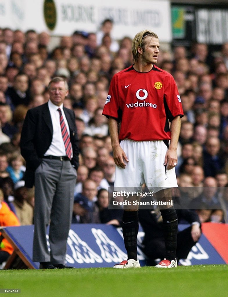 David Beckham of Manchester United and his manager Sir Alex Ferguson look in different directions