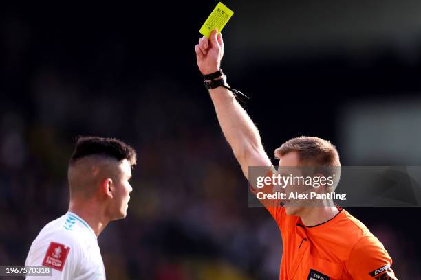 Referee Michael Salisbury shows a yellow card to Carlos Alcaraz of Southampton during the Emirates FA Cup Fourth Round match between Watford and...