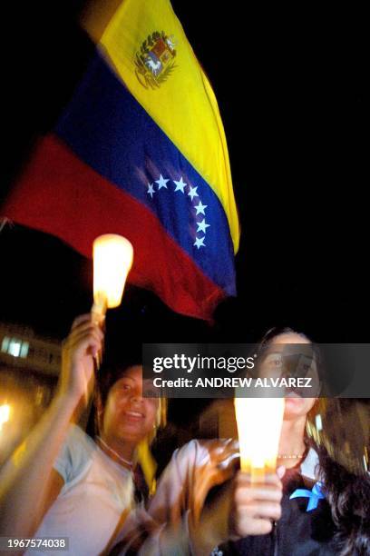 Group of girls, daughters of officials who rebelled against Chavez, carry candels and pray at a plaza in Caracas, 08 June 2002. AFP PHOTO/Andrew...
