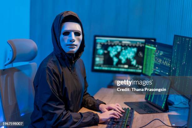 masked anonymous hacker organizes malware attack on global scale. - stolen identity stock pictures, royalty-free photos & images