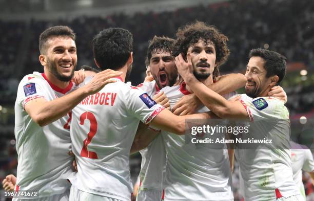 Vakhdat Khanonov of Tajikistan celebrates scoring his team's first goal with teammates during the AFC Asian Cup Round of 16 match between Tajikistan...