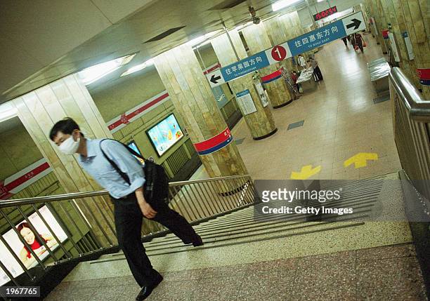 A man wearing a protective mask leaves the almost deserted subway station in Jianguomenwai, Beijing, on May 2, 2003. At least 82 people have died in...
