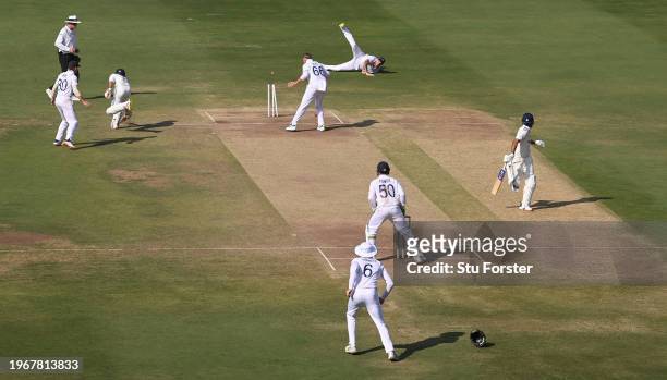 England captain Ben Stokes throws the ball to run out India batsman Ravindra Jadeja as bowler Joe Root looks on during day four of the 1st Test Match...
