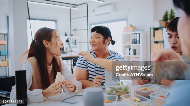 office diversity: colleagues enjoying lunch break snacks for enhanced bonding - meaningful stock pictures, royalty-free photos & images