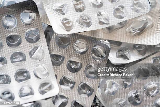 Detail of generic silver medication foils that once contained tablets, treatments and pharmaceutical products, on 31st January 2024, in London,...