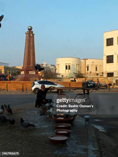 people feeding birds on footpath and crossing in different neighborhood of karachi - world kindness day stock-fotos und bilder