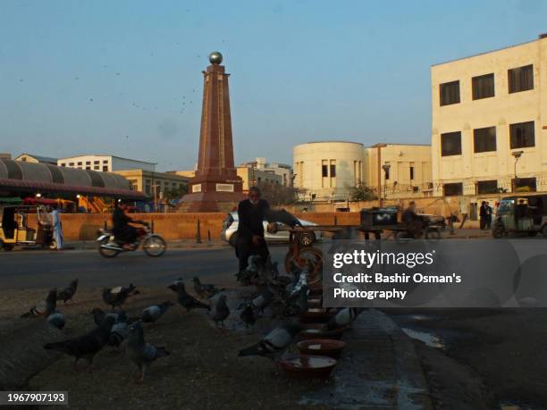 people feeding birds on footpath and crossing in different neighborhood of karachi - world kindness day stock-fotos und bilder