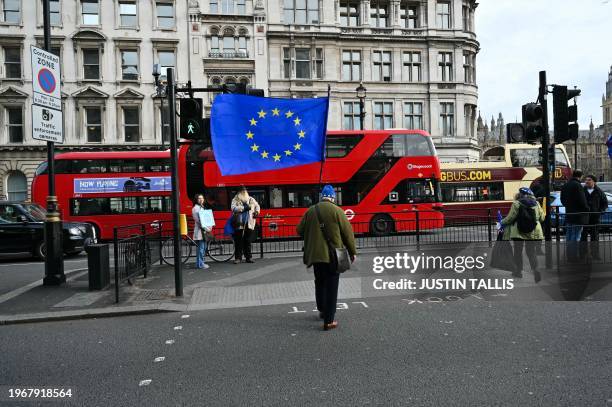 Anti-Brexit supporter waving a European Union flag walks towards the Palace of Westminster, home to the Houses of Parliament, central London, on...