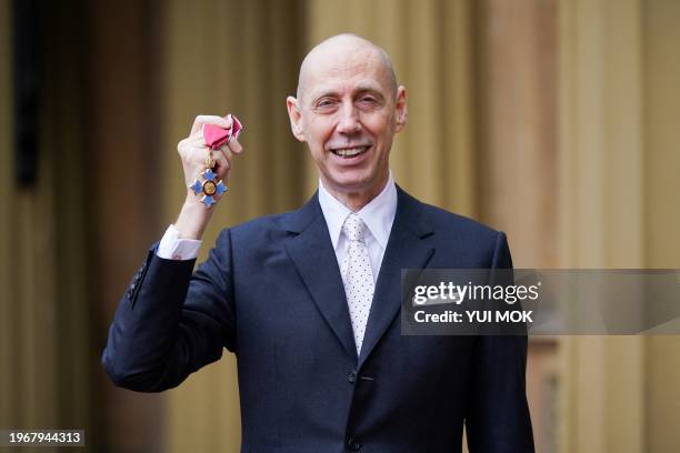 Fashion photographer Nick Knight poses with their medal after being appointed a Commander of the Order of the British Empire following an investiture...