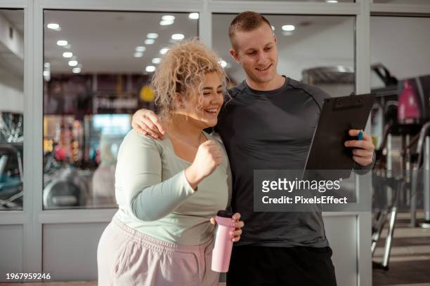 happy plus size woman talking to fitness instructor - obesity trainer stock pictures, royalty-free photos & images