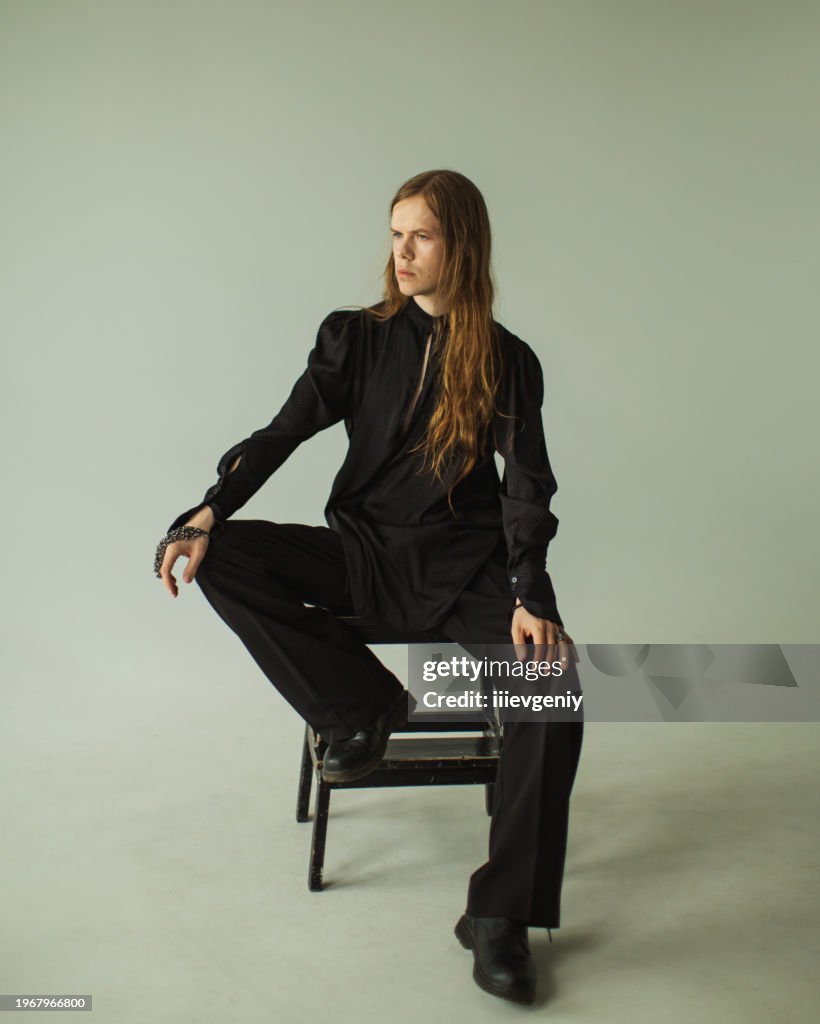 Long hair man in studio. Gothic style