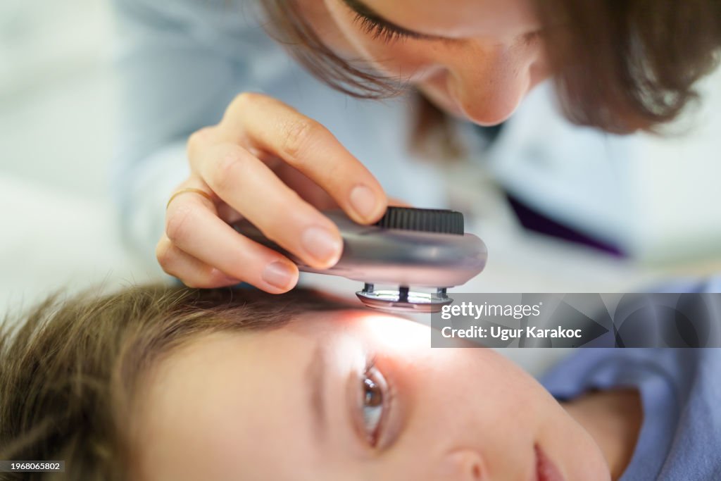 Dermatologist is using dermatoscope for child skin examination