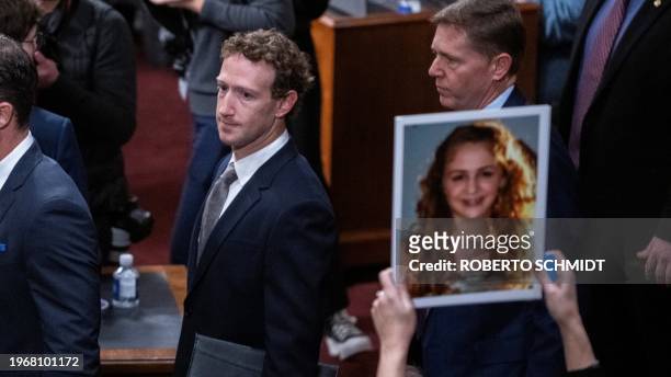 Mark Zuckerberg, CEO of Meta, walks past the photo of a victim of child exploitation as he arrives for a full committee hearing on "Big Tech and the...