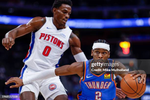 Shai Gilgeous-Alexander of the Oklahoma City Thunder dribbles the ball against Jalen Duren of the Detroit Pistons in the first quarter of a game at...