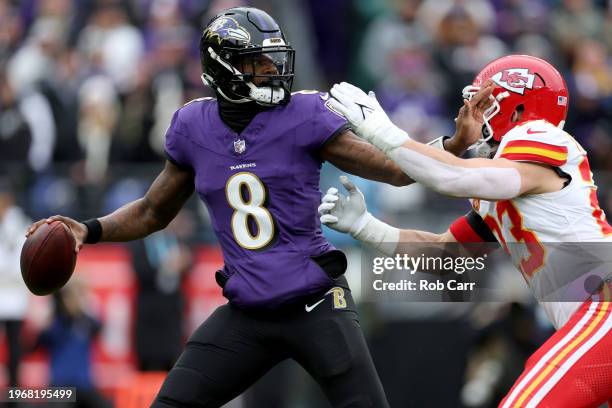 Lamar Jackson of the Baltimore Ravens is pressured by Drue Tranquill of the Kansas City Chiefs during the first quarter in the AFC Championship Game...