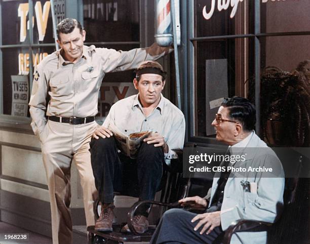 American actors Andy Griffith, George Lindsey, and Howard McNear sit outside a barber shop in a still from the television series, 'The Andy Griffith...