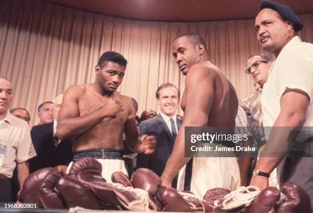 World Heavyweight Champion Sonny Liston poses with challenger Floyd Patterson at the weigh-in for their title fight rematch. Liston knocked out...
