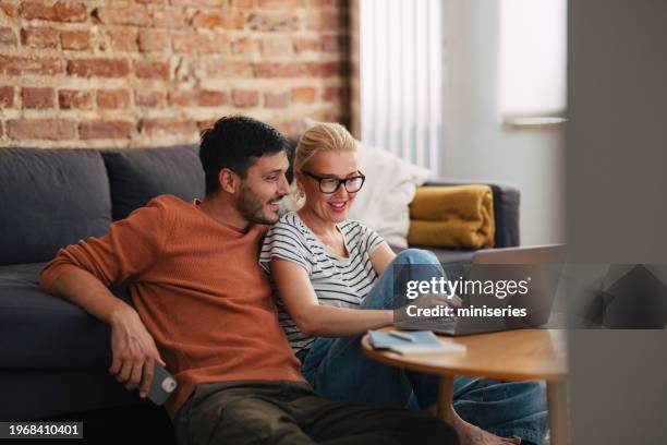 loving couple relaxing in the afternoon and watching something on the laptop computer - two parents stock pictures, royalty-free photos & images