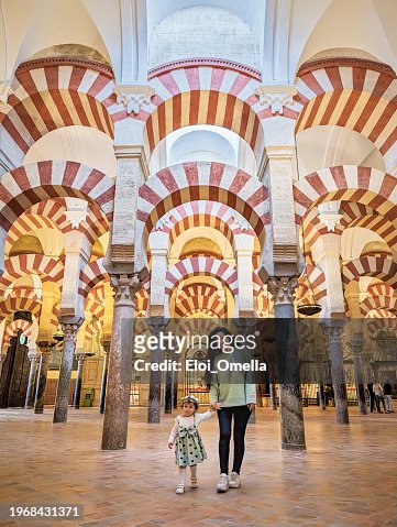 Mother and young daughter visiting the interior of the Mosque Cathedral of Cordoba in Spain