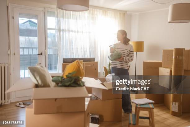 happy young woman in new apartment - uitpakken activiteit stockfoto's en -beelden