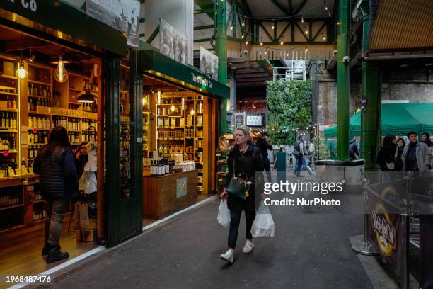 Woman is carrying bags as she walks through Borough Market in London, on January 30, 2024.