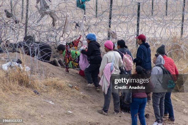 Group of migrants from different nationalities attempt to cross Mexico-United States border along razor wire despite heightened security measures, in...