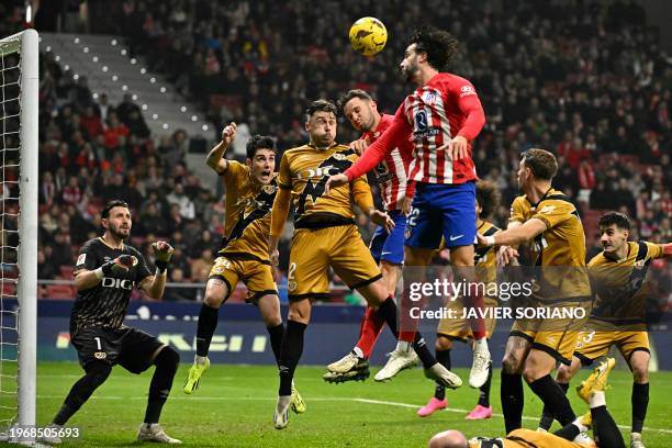 Atletico Madrid's Spanish defender Mario Hermoso and Atletico Madrid's Spanish midfielder Saul Niguez vie for a header with Rayo Vallecano's Rumanian...