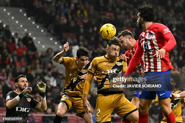 Atletico Madrid's Spanish defender Mario Hermoso and Atletico Madrid's Spanish midfielder Saul Niguez vie for a header with Rayo Vallecano's Rumanian...