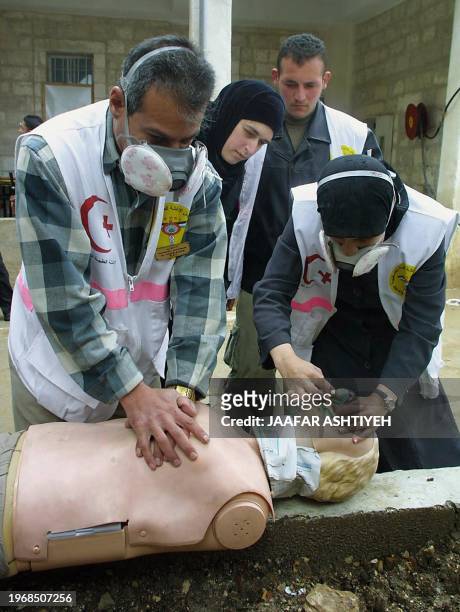 Palestinian medics demonstrate how to care for chemical attack victims in the West Bank town of Nablus 19 March 2003. Preventive exercises are taking...