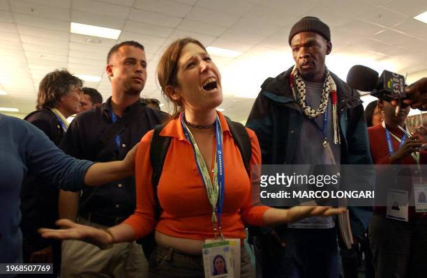 An Israeli delegate cries for the killings in Israel while a Palestinian supporter looks at the end of a Palestinian press conference 26 August 2002...