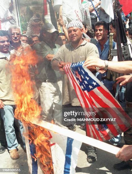 Palestinian demonstrators burn Israeli and American flags at the Ain el-Helweh refugee camp 21 July 2002 in southern Lebanon. Hundreds of Palestinian...