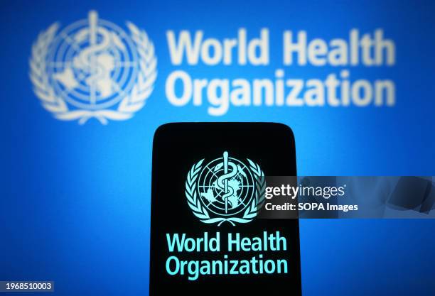 In this photo illustration, the World Health Organization logo is seen on a smartphone and in the background.