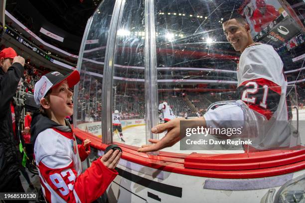 Mathieu Joseph of the Ottawa Senators give a young Detroit Red Wings fan a puck in warm ups before the game at Little Caesars Arena on January 31,...