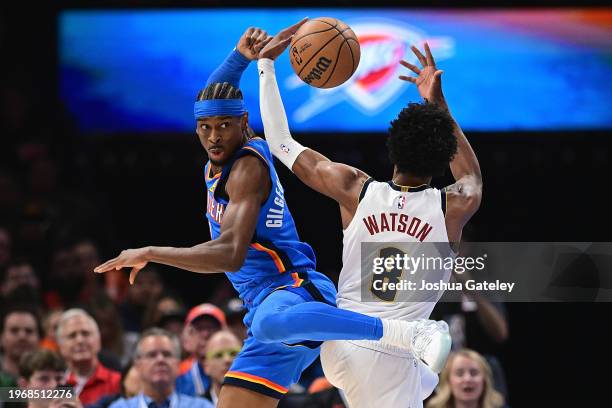 Shai Gilgeous-Alexander of the Oklahoma City Thunder gets tangled up with Peyton Watson of the Denver Nuggets in the first half at Paycom Center on...