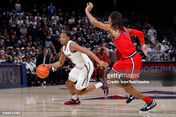 Xavier Musketeers guard Quincy Olivari handles the ball while defended by St. John's Red Storm guard Daniss Jenkins during a college basketball game...