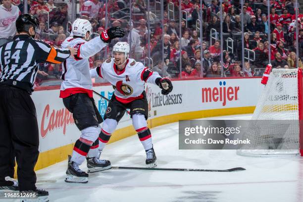 Shane Pinto of the Ottawa Senators scores the game winning goal in O.T. On Alex Lyon of the Detroit Red Wings and celebrates with Thomas Chabot at...