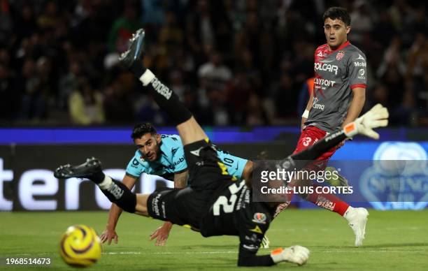 Pumas' Eduardo Salvio attempts to score past Necaxa's Agustin Oliveros and goalkeeper Luis Unsain during the Mexican Clausura 2024 tournament...