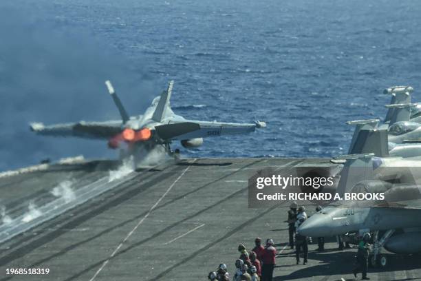 An F/A-18 fighter jet takes off from the deck of the USS Carl Vinson aircraft carrier during a three-day maritime exercise between the US and Japan...
