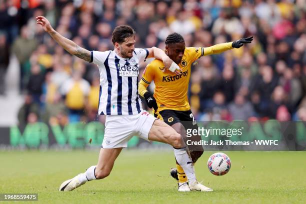 Jean-Ricner Bellegarde of Wolverhampton Wanderers is challenged by Okay Yokuslu of West Bromwich Albion during the Emirates FA Cup Fourth Round match...