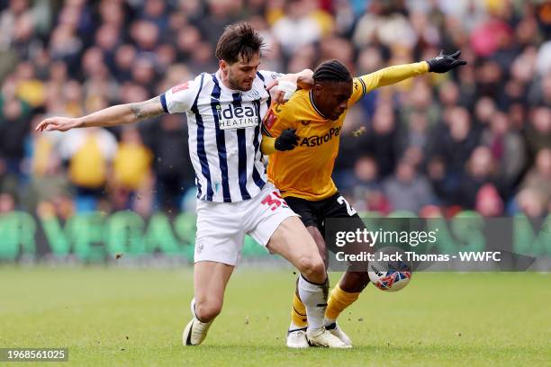 Jean-Ricner Bellegarde of Wolverhampton Wanderers is challenged by Okay Yokuslu of West Bromwich Albion during the Emirates FA Cup Fourth Round match...