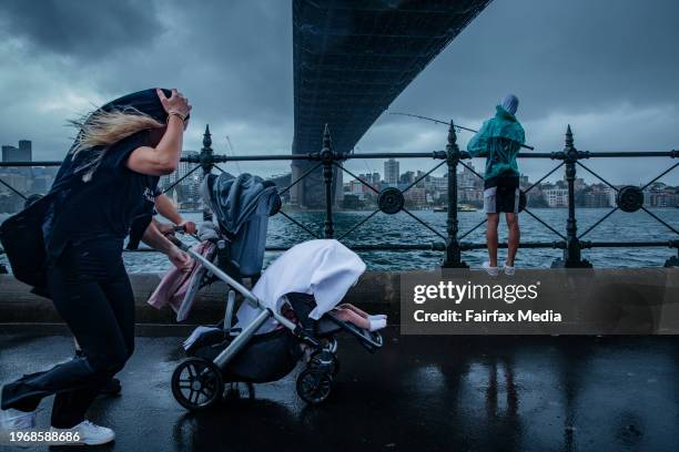 People venture out under the Sydney Harbour Bridge at The Rocks despite the wet condition. January 15th, 2024. Sydneysiders have been warned to brace...