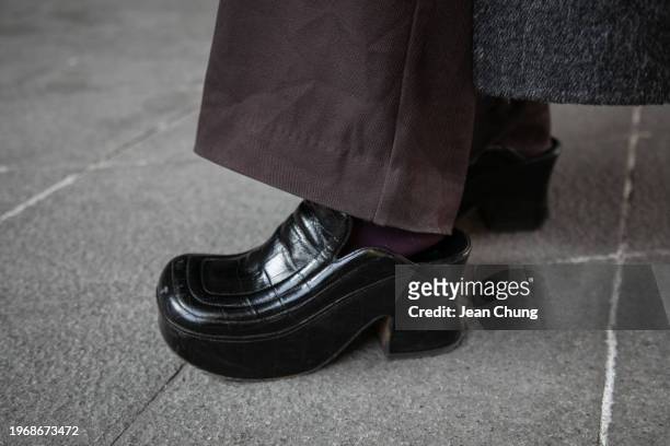 Wu QinQin wears a black 4mile coat, a black Prada triangle bag, and a pair of black Bottega Veneta chunky mules during Seoul Fashion Week F/W 2024 on...