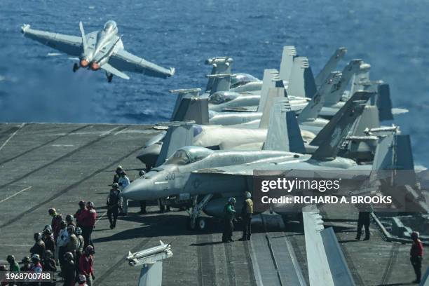 An F/A-18 fighter jet takes off from the deck of the USS Carl Vinson aircraft carrier during a three-day maritime exercise between the US and Japan...