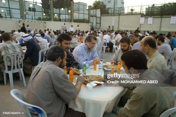 Nafez Azam , a senior member of the Palestinian Islamic Jihad movement, eats with families of Palestinian "martyrs" of the Isareli-Palestinian...