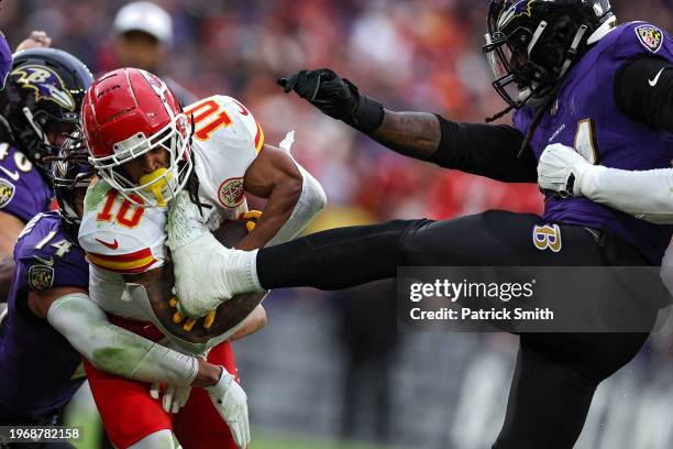 Isiah Pacheco of the Kansas City Chiefs is kicked by Jadeveon Clowney of the Baltimore Ravens during the second quarter in the AFC Championship Game...