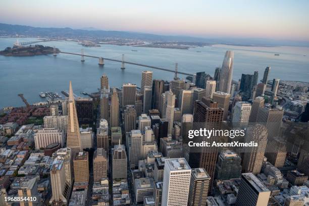 aerial view of city skyline, calm bay and bridge at sunset - san francisco financial district stock pictures, royalty-free photos & images