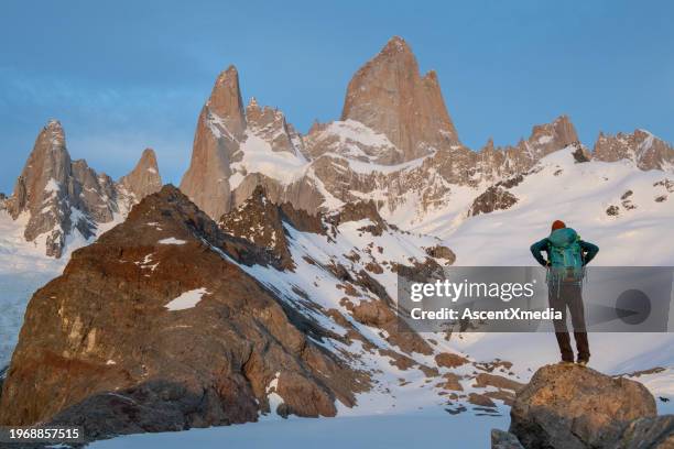 mochilero se para en la roca debajo de la cordillera - monte fitz roy fotografías e imágenes de stock
