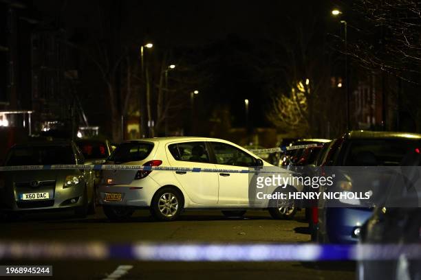 Car is seen behind police cordon after a suspected corrosive substance attack in south London on February 1, 2024. UK police were on Thursday hunting...